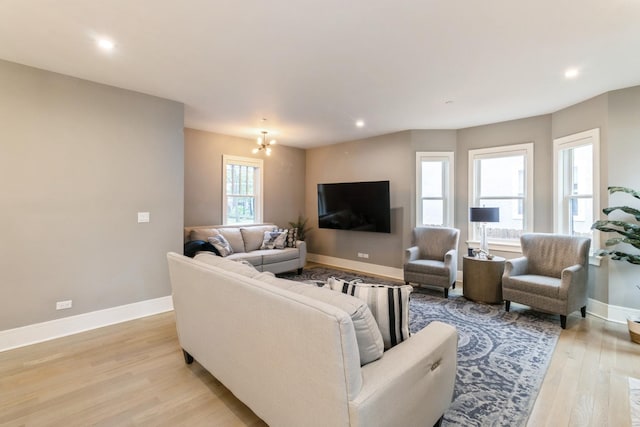 living area featuring light wood finished floors, baseboards, recessed lighting, and a chandelier
