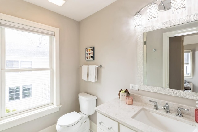 bathroom with toilet, baseboards, and vanity