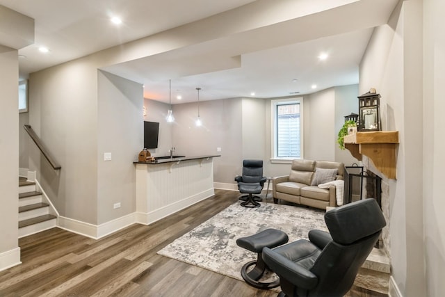living room with wood finished floors, baseboards, stairway, recessed lighting, and a fireplace