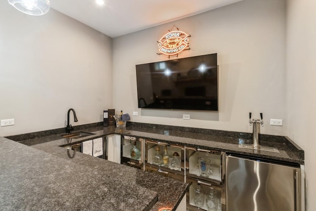 bar with a sink and refrigerator
