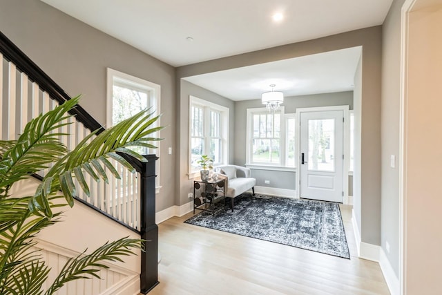 foyer featuring a wealth of natural light, wood finished floors, baseboards, and stairs