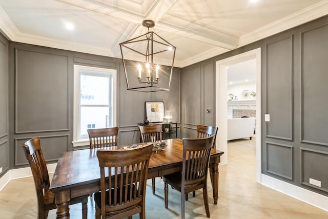 dining room with a decorative wall, ornamental molding, a chandelier, and light wood-style floors