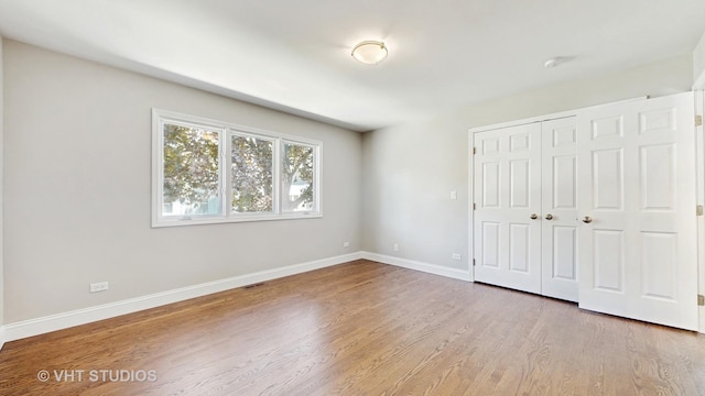 1544 N Wolf Rd, Berkeley, IL 60163 - unfurnished bedroom featuring wood finished floors, baseboards, and a closet