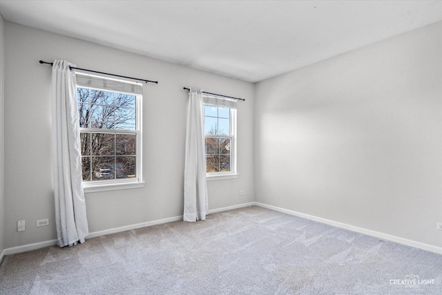 carpeted spare room featuring baseboards