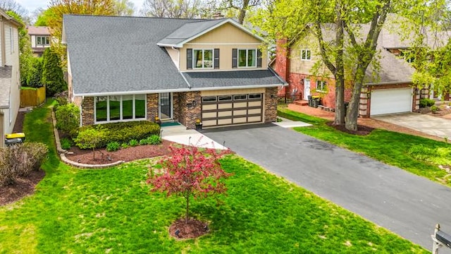 craftsman house with brick siding, a front lawn, an attached garage, and driveway