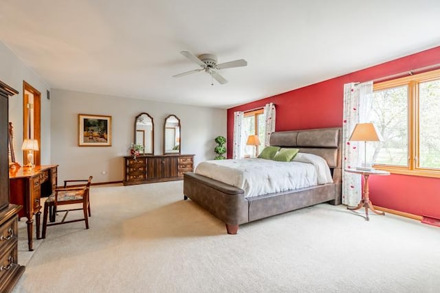 carpeted bedroom featuring baseboards, ceiling fan, and multiple windows