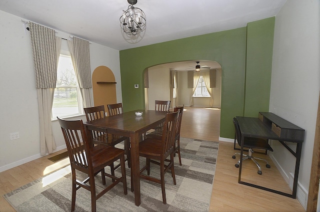 112 W Porter St, Oglesby, IL 61348 - dining room with baseboards, arched walkways, light wood-style flooring, and a ceiling fan