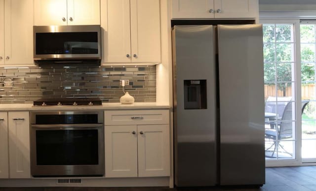kitchen featuring light countertops, white cabinetry, appliances with stainless steel finishes, and tasteful backsplash