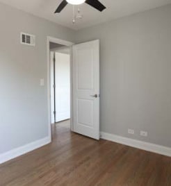 unfurnished room with visible vents, a ceiling fan, baseboards, and wood finished floors