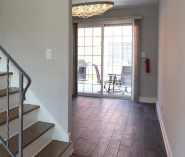 interior space featuring brick floor, baseboards, and stairs
