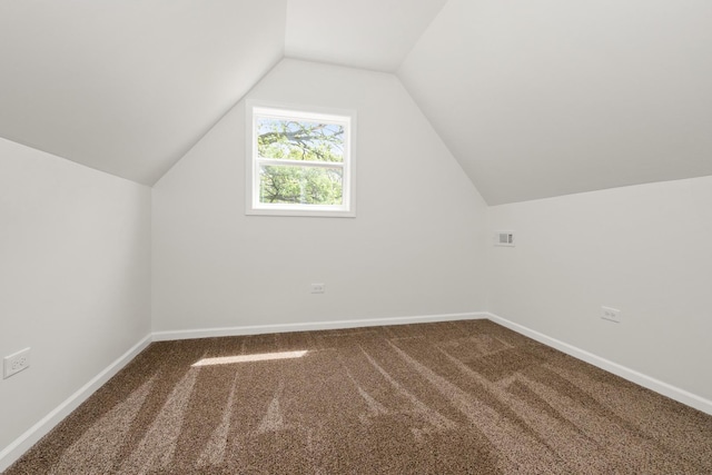 additional living space featuring carpet, lofted ceiling, and baseboards