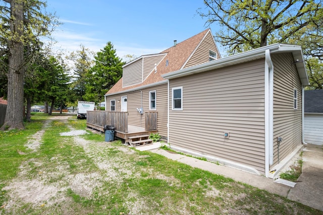 back of property with a deck and a shingled roof