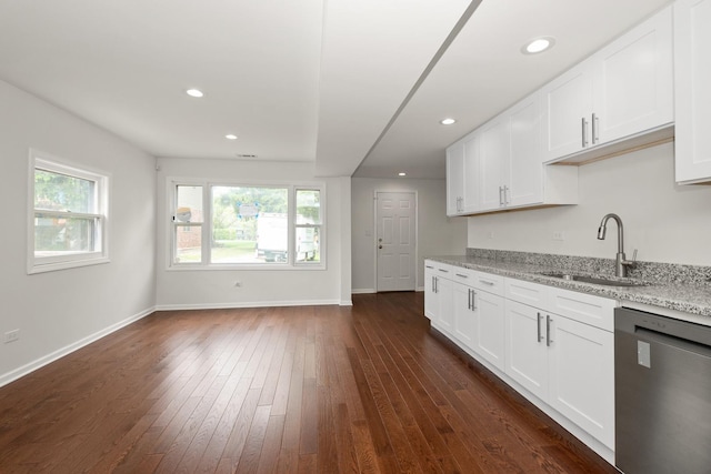 kitchen featuring dishwasher, a sink, light stone countertops, dark wood-style flooring, and recessed lighting