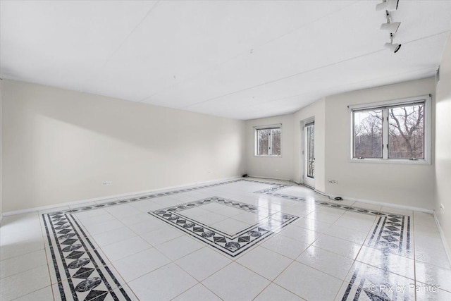 unfurnished living room featuring baseboards and a healthy amount of sunlight