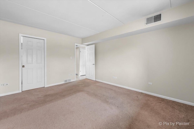 spare room featuring baseboards, visible vents, and carpet floors
