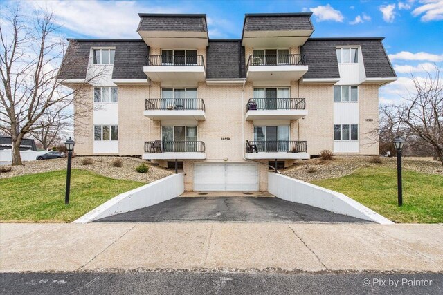 view of building exterior with aphalt driveway and a garage