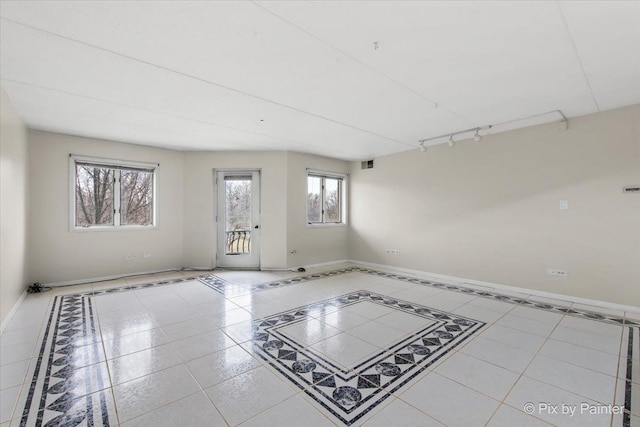 unfurnished room featuring track lighting, visible vents, and baseboards