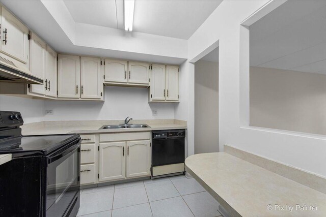 kitchen featuring a sink, black appliances, light tile patterned flooring, light countertops, and under cabinet range hood
