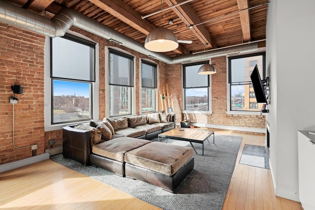 interior space with wood ceiling, brick wall, wood-type flooring, and a healthy amount of sunlight
