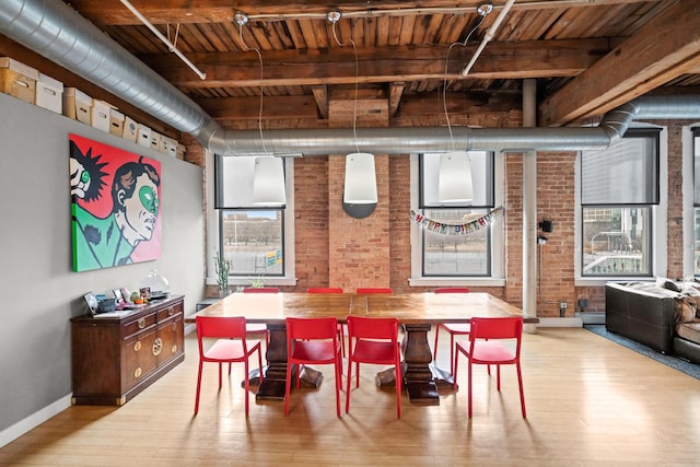 dining space with wood ceiling, brick wall, baseboards, and wood finished floors