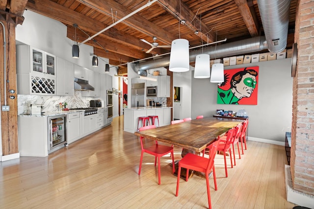 dining room with beverage cooler, wood ceiling, light wood-style flooring, baseboards, and beam ceiling