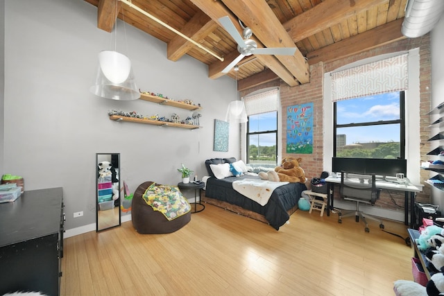 bedroom with brick wall, wooden ceiling, wood finished floors, and beamed ceiling