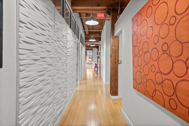 corridor with light wood finished floors and baseboards