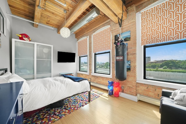 bedroom featuring beam ceiling, brick wall, baseboard heating, wood finished floors, and wood ceiling