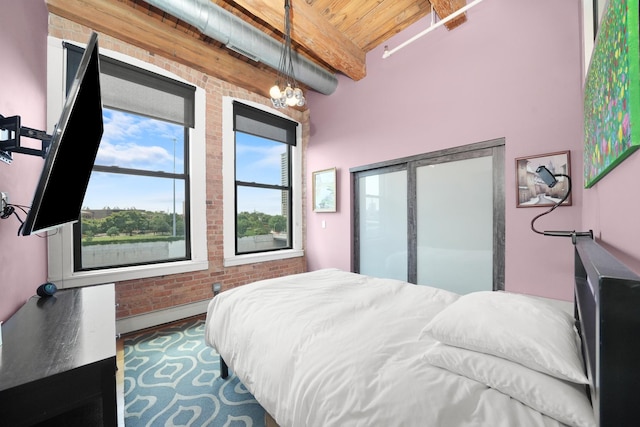 bedroom with a chandelier, beamed ceiling, wood ceiling, a baseboard radiator, and brick wall