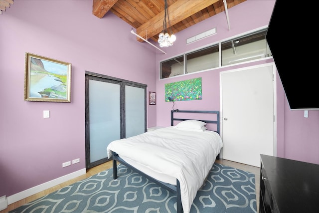 bedroom with wood finished floors, a closet, wood ceiling, an inviting chandelier, and beamed ceiling