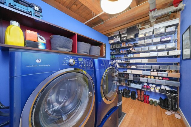washroom featuring wood finished floors, laundry area, and independent washer and dryer