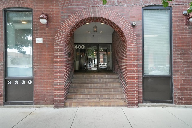 entrance to property featuring brick siding