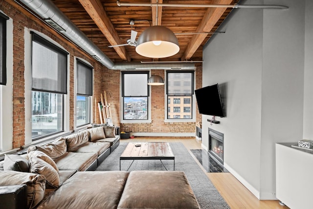 living room with wood finished floors, a high end fireplace, brick wall, wooden ceiling, and beam ceiling