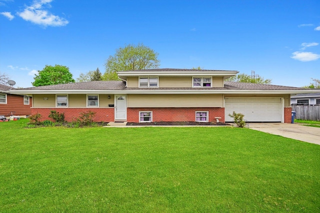 split level home with fence, a front yard, brick siding, an attached garage, and driveway