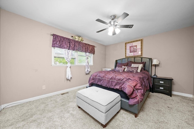 carpeted bedroom featuring baseboards, a ceiling fan, and visible vents