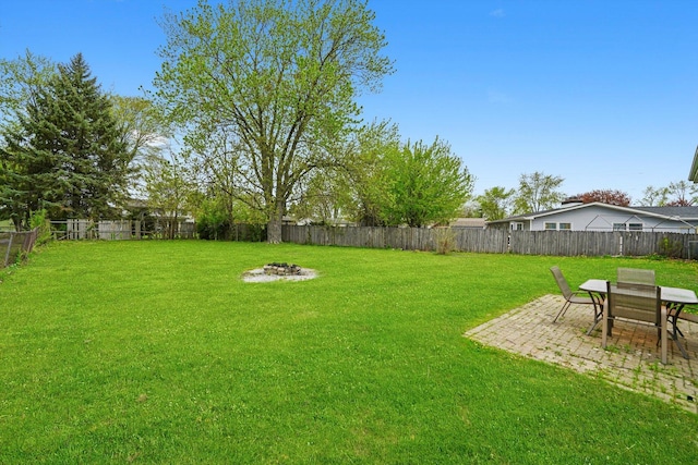 view of yard featuring a fenced backyard, a patio, and an outdoor fire pit