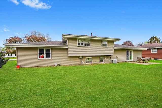 rear view of house with central air condition unit, a lawn, and a patio area