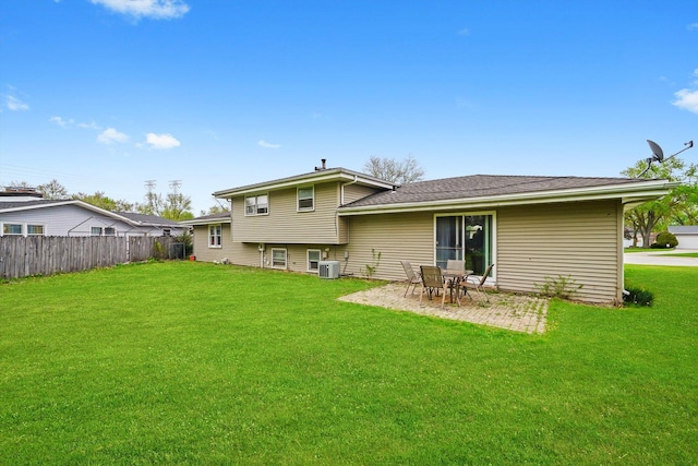 rear view of property with a yard, fence, central AC unit, and a patio area