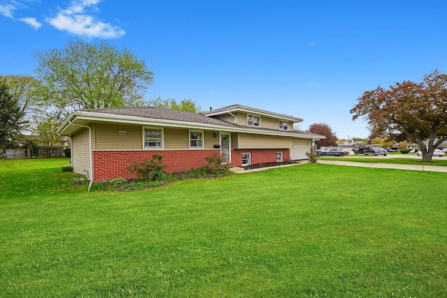 tri-level home with concrete driveway, brick siding, a front yard, and a garage