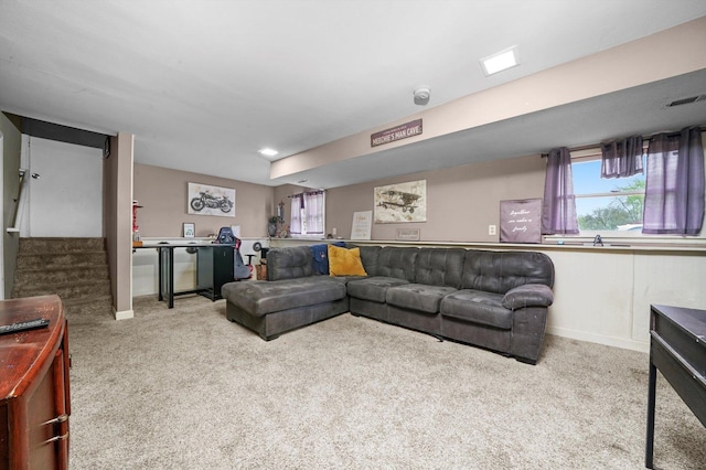 carpeted living area featuring visible vents, baseboards, and stairway