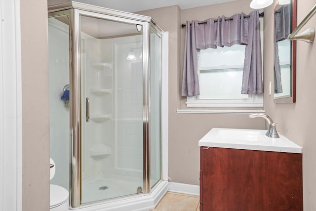 full bathroom featuring vanity, toilet, baseboards, tile patterned floors, and a shower stall