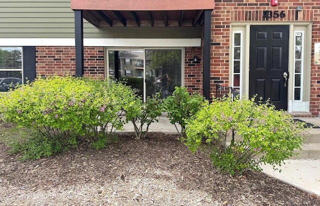 view of exterior entry featuring brick siding