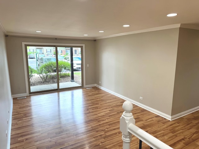spare room with crown molding, baseboards, wood finished floors, and recessed lighting
