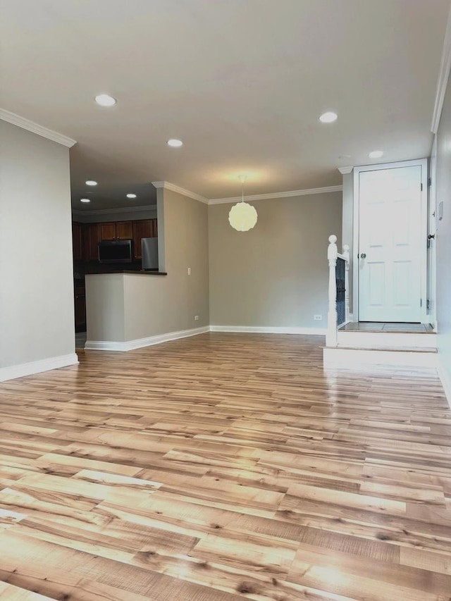 unfurnished living room featuring light wood-style flooring, baseboards, crown molding, and recessed lighting