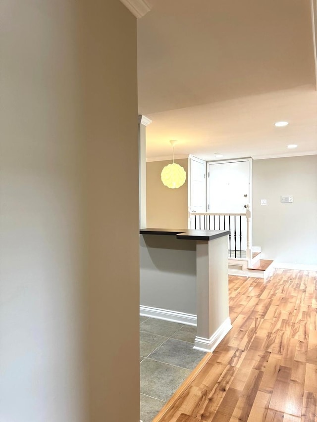 hall with ornamental molding, baseboards, an upstairs landing, recessed lighting, and light wood-type flooring