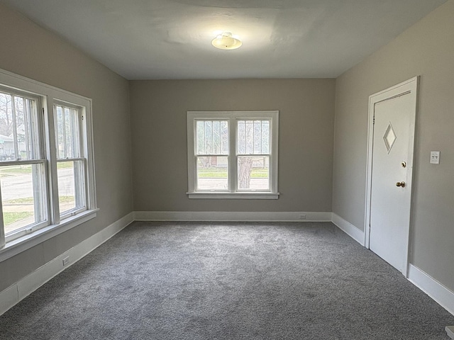 carpeted empty room featuring baseboards