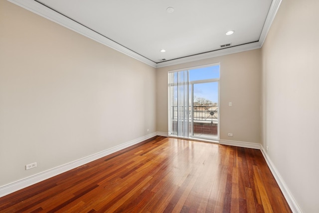 spare room featuring baseboards, visible vents, hardwood / wood-style flooring, and ornamental molding