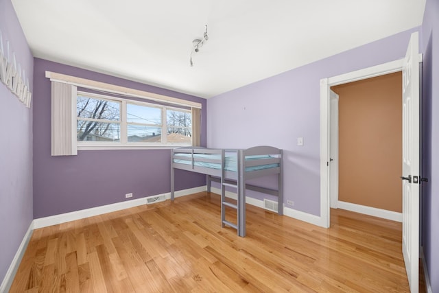bedroom with visible vents, baseboards, and light wood-type flooring