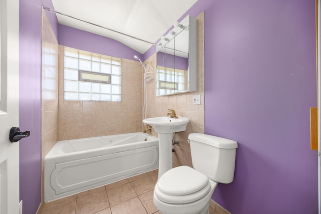 bathroom with tile patterned flooring, shower / tub combination, tile walls, and toilet