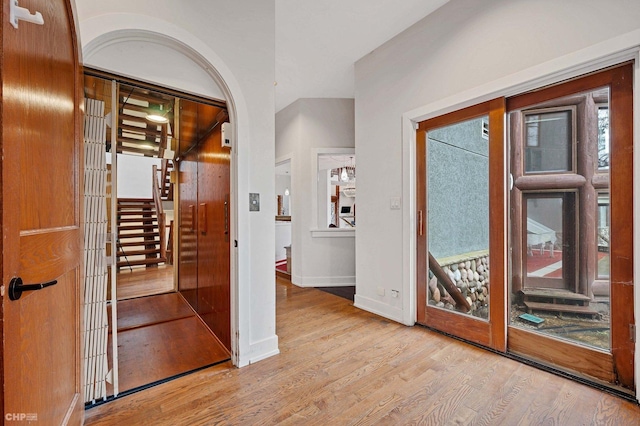 interior space featuring baseboards, wood finished floors, and stairs